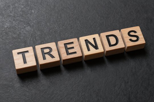 Wooden blocks spelling TRENDS on dark background representing market analysis and business strategy