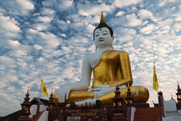 Obraz premium Large buddha statue in the midst of Chiang Mai city in northern Thailand with puffy white clouds (Thailand, South East Asia)