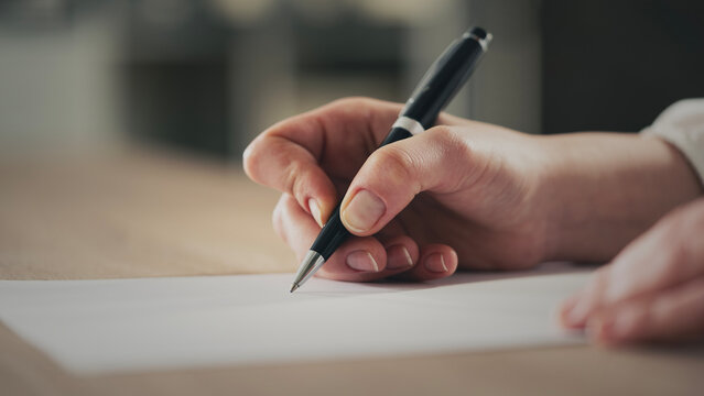 Close up of an unrecognizable woman signing contract paper