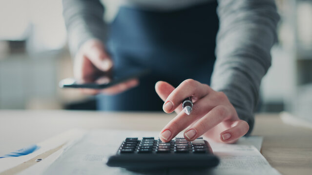Close-up view woman's hand using a calculator