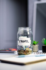 Travel savings in jar. Money being added to travel themed savings container. Inspires adventure planning and purposeful financial habits © Krievietka