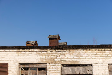 abandoned building made of brick in the winter, an abandoned building intended for demolition, the entrances and windows to the building are boarded up, blue sky
