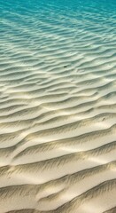 Detailed view of the sandy bottom of the clear ocean floor, showing subtle ripples and textures created by water movement and currents, water, vacation, pattern