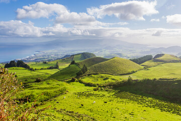 Title: Panoramic view of lush green volcanic hills and coastline on Sao Miguel Island, Azores, Portugal.