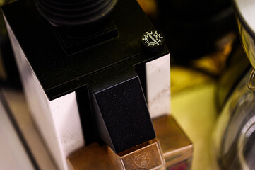 A sleek coffee grinder component with matte black and metallic bronze parts, featuring a...