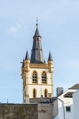 Obraz premium A square tower with a pointed black roof in the city of Trier, Germany There is a cross on the top of the tower, not a rooster