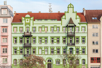 Obraz premium A green building with a red roof and a balcony in Pilsen Czech Republic. The building is tall and has many windows
