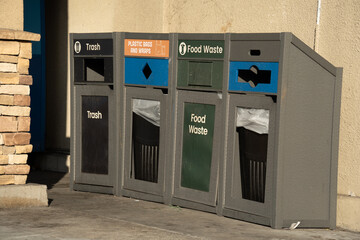 Modern recycling bins for trash, food waste, and plastic bags and wraps