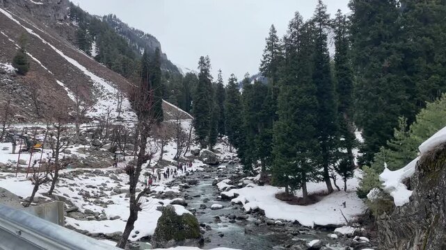 Scenic natural beauty of Chandanwari Valley featuring rocky landscapes, flowing streams, snow patches, and majestic Himalayan mountains near Pahalgam, Kashmir.