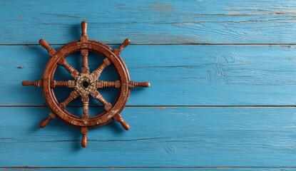 Obraz premium Nautical Compass on Blue: A classic wooden ship's wheel rests on a textured blue wooden surface. The interplay of the weathered wood and vibrant blue creates a captivating contrast.