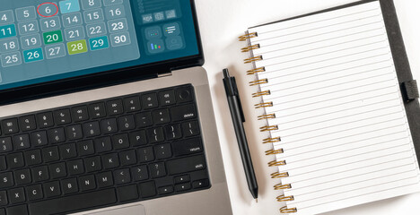Laptop calendar with blank notebook for planning