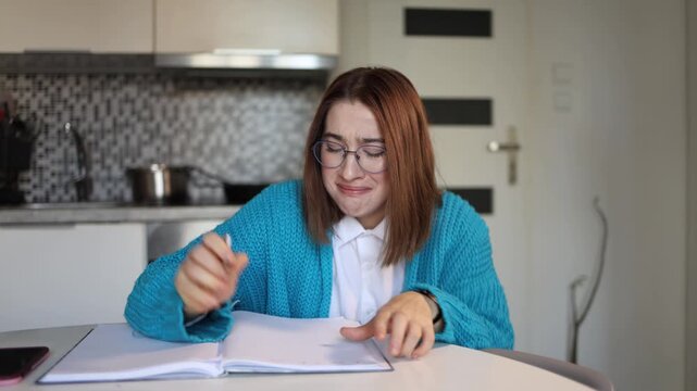 Young woman violently rips handwritten pages crying at table emotional collapse during therapeutic writing as unresolved family pain finally erupts