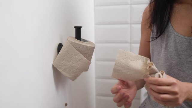 Asian woman holding toilet paper roll while sitting on toilet bowl. digestion, constipation, Diarrhea from food poisoning, infection, abdominal, stomachache, cystitis, Insurance, Health care and Medic