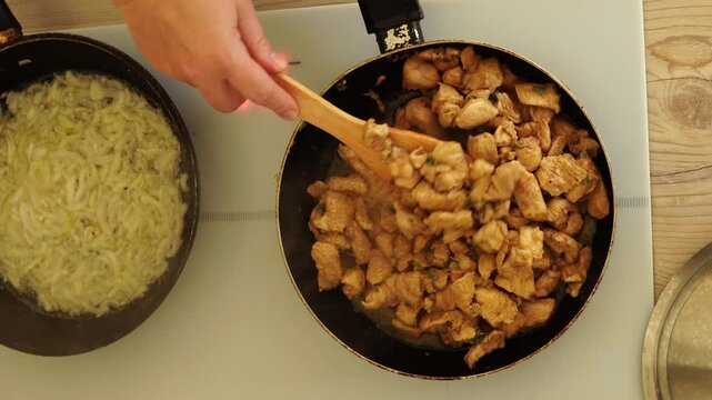 Top view - preparation of chicken pieces in a frying pan

