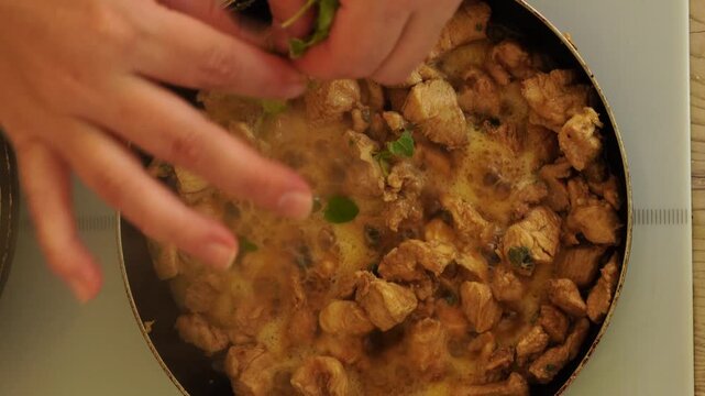 Top view - preparation of chicken pieces in a frying pan
