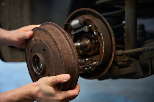 Caucasian man holds an old brake drum