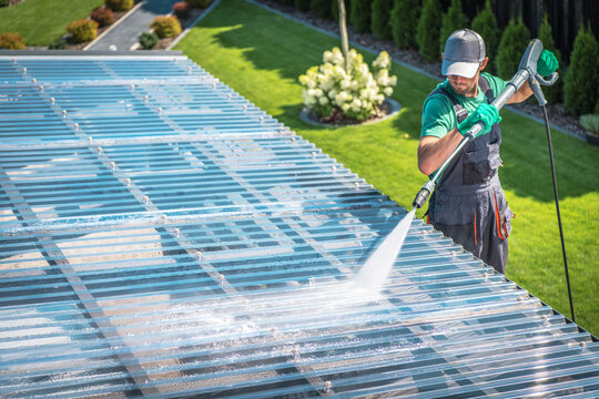 Worker Uses Pressure Washer Outdoors