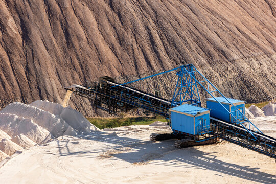 Industrial mining conveyor system transports mineral material potash dump sunlight day. Scene extraction process heavy machinery industrial infrastructure raw resources engineering arid environment