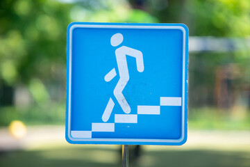 Blue square information road sign "Underground pedestrian crossing" with a white silhouette of a person walking down the stairs.