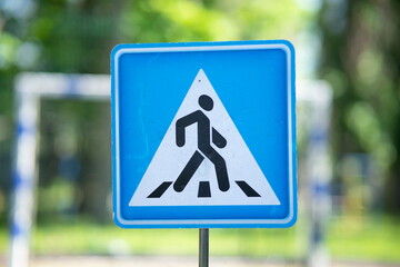 Square blue information road sign "Pedestrian crossing" with a white triangle and walking person silhouette.