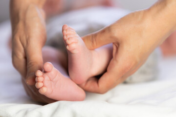 Parent hands gently holding newborn baby feet