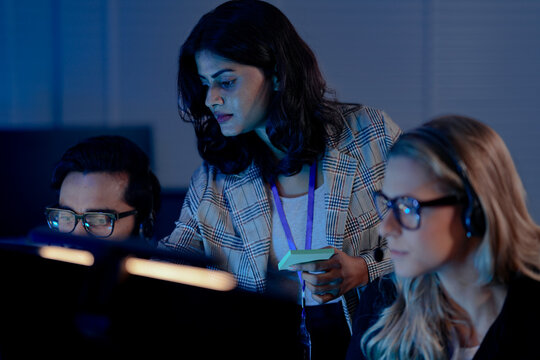 A future call center manager uses an AI platform showing predictive analytics on agent performance, identifying coaching needs in real time for optimized customer interactions.