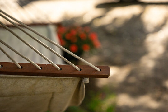 Drewniany fragment hamaka z przeplecionymi przez niego linkami