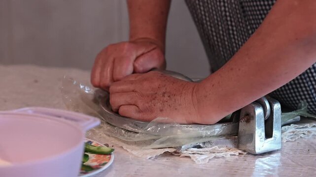 Close-up of a mature woman's hands preparing corn tortillas by hand