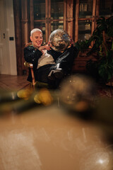 Obraz premium Bald woman celebrating a festive party, holding a sparkling disco ball and laughing in a glamorous outfit