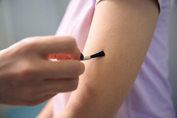 Doctor neurologist using neurological brush for female patient in clinic