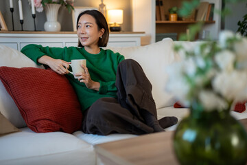 Obraz premium Woman relaxing at home enjoying cup of coffee