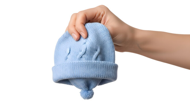 A hand holding a blue baby bootie isolated on transparent background