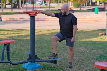 Man Using Outdoor Fitness Equipment in Public Park. Healthy Lifestyle Exercise in City Park. Man Training on Outdoor Gym Equipment. Public Park Fitness Equipment Workout.