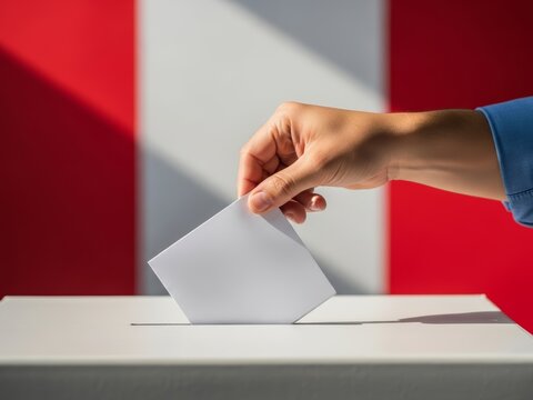 Close-up of a voter's hand putting a ballot paper into the white election box with the flag of Peru in the background. Concept of democracy, presidential or parliamentary elections and political choic