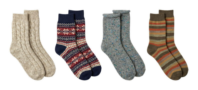 Four pairs of warm cozy winter socks displayed together, showcasing a variety of patterns including cable knit, Fair Isle, speckled, and classic stripes, perfect for cold weather comfort.