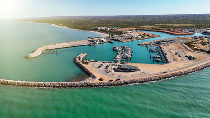 Naklejka premium Drone shot of Exmouth harbor Western Australia capturing marina, coastline, and surrounding outback