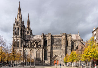 Obraz premium Clermont-Ferrand, France - 10 24 2025: Panoramic view of the Cathedral of Our Lady of the Assumption building and Place de la Victoire with autumn color