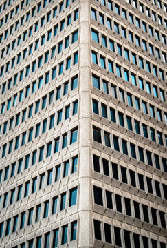 Fachada de edificio de oficinas moderno con ventanas repetitivas en &aacute;ngulo de esquina, arquitectura brutalista de hormig&oacute;n.