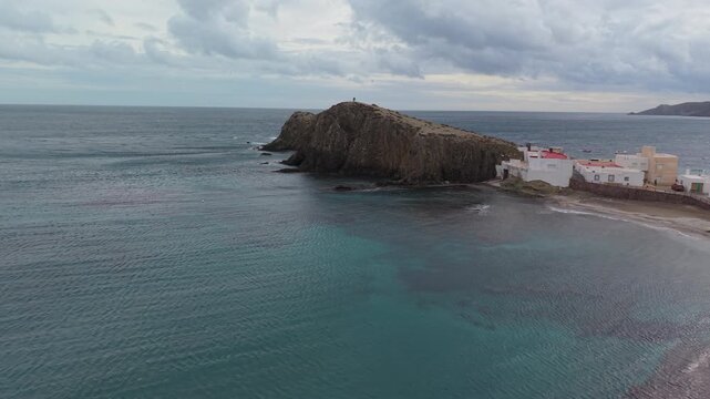 Aerial perspective of Del Penon Blanco beach with turquoise waters and white village houses, Nijar, Almeria, Andalusia