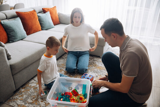 Family plays with toys in living room during daytime activities together