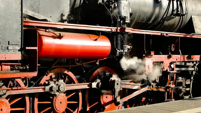 Close-up of steam locomotive wheels and connecting rods at station