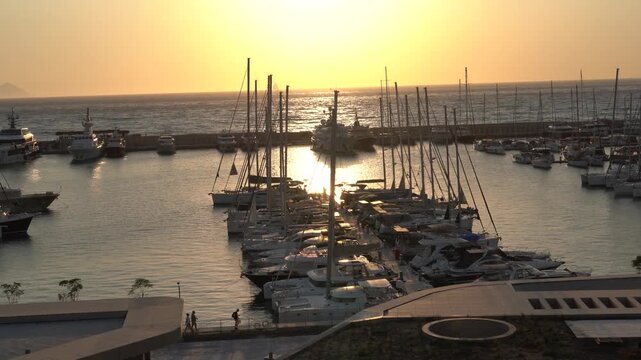  Panoramic sunset view of the crowded Kusadasi marina with luxury yachts and cityscape in the background, Kusadasi, Aydın, Turkey