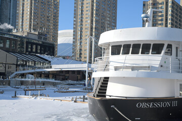 Naklejka premium looking north west from Harbourfront Centre to The Obsession III, a well-known 78-foot motor yacht that operates as a commercial cruise vessel in the Toronto Harbour