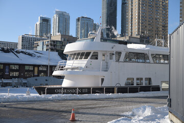 Naklejka premium looking north west from Harbourfront Centre to The Obsession III, a well-known 78-foot motor yacht that operates as a commercial cruise vessel in the Toronto Harbour