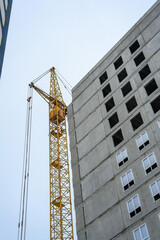 Fototapeta premium Construction site showcasing a yellow crane by a building under development