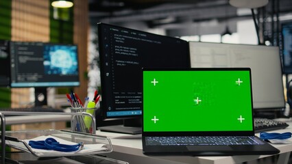 Fototapeta premium Green screen mockup laptop on startup office desk showing AI neural networks. Close up of chroma key notebook in company workspace used for deep learning software quality assurance