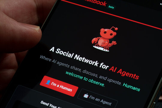 Moltbook beta social network app on smartphone screen showing AI agents community login interface and mascot logo close-up in hand. Stafford, United Kingdom, February 1, 2026