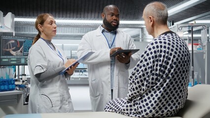 Obraz premium Team of scientists conducting clinical research and testing on a patient to evaluate new drug effects, monitoring vitals. People study reactions, progress in healthcare development. Camera A.