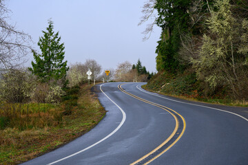 Obraz premium Road curves through lush countryside with no overtaking double yellow lines