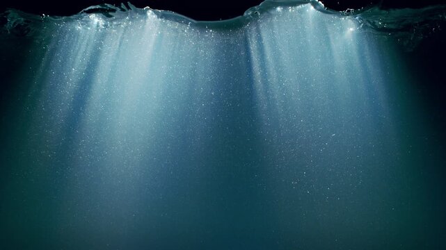 Dark Blue Ocean Surface Seen from Underwater , Super Slow Motion . Abstract Waves and Rays of Sunlight Shining Through